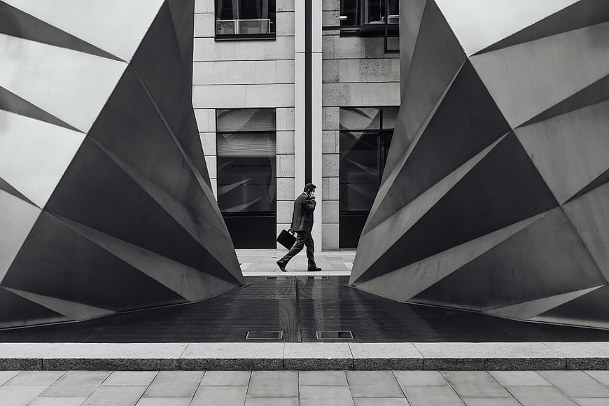 Businessman walking between modern geometric sculptures