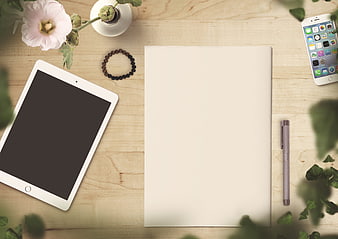 Flat lay workspace with tablet, notebook, and smartphone on wooden desk