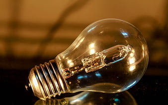Close-up of vintage incandescent light bulb on dark surface