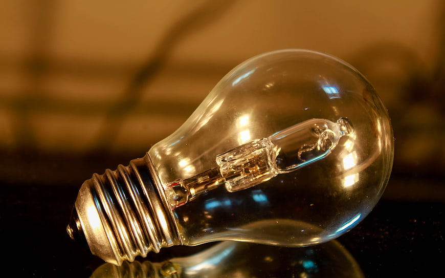 Close-up of vintage incandescent light bulb on dark surface