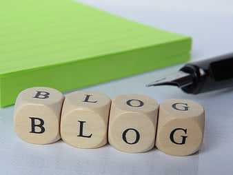 Wooden cubes spelling blog with green notebook and pen