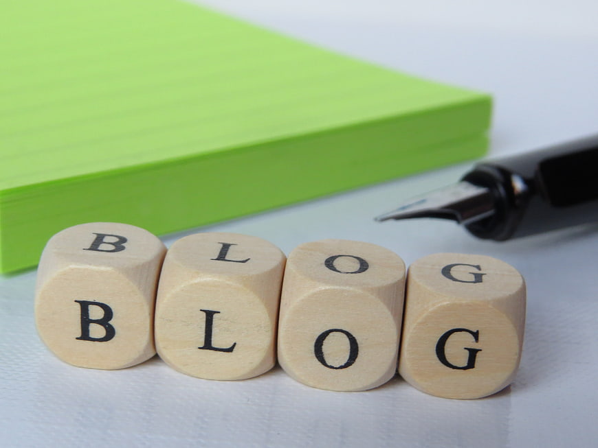 Wooden cubes spelling blog with green notebook and pen