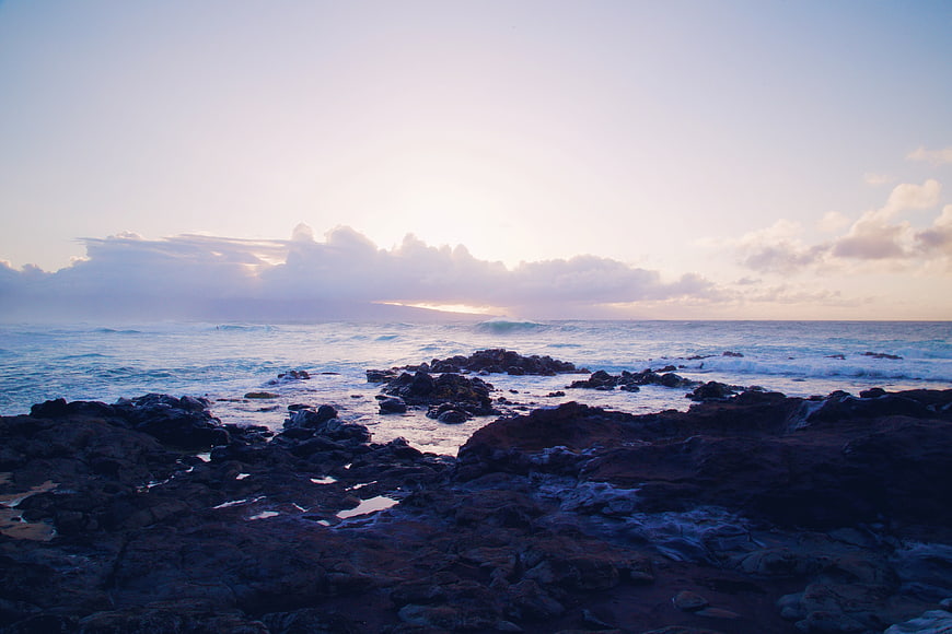 Dramatic Sunset Over Rocky Ocean Coastline with Clouds