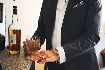 Man in Suit Holding Whiskey Glass at Bar
