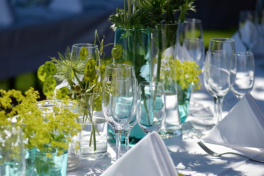 Elegant Outdoor Table Setting With Glassware And Floral Centerpieces