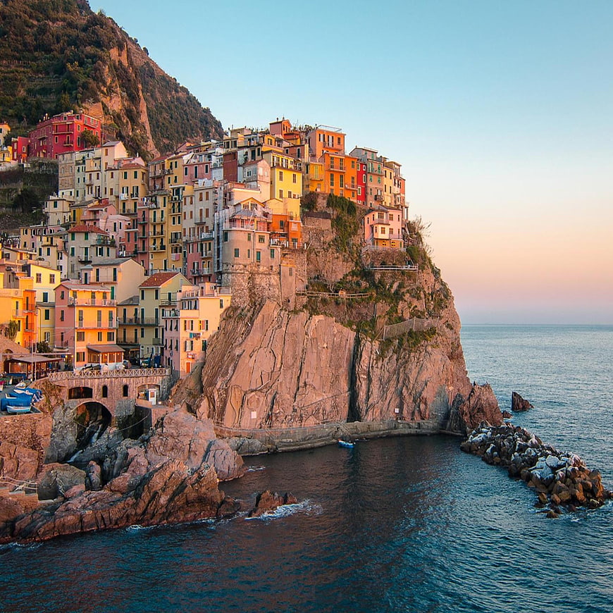 Colorful houses on cliffs in Cinque Terre, Italy at sunset
