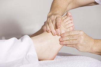 Close-up of professional foot massage therapy on white towel
