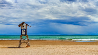 Lifeguard Tower on Sandy Beach with Blue Sky and Ocean