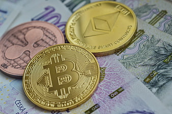 Bitcoin, Ethereum, and Ripple coins on Czech banknotes