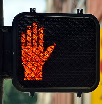 Close-up of red hand pedestrian stop signal