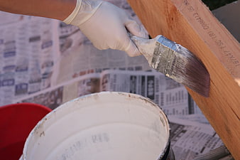 Hand in Glove Painting Wood with Brush and White Paint