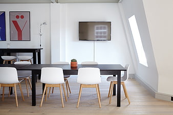 Modern minimalist office meeting room with black table and white chairs