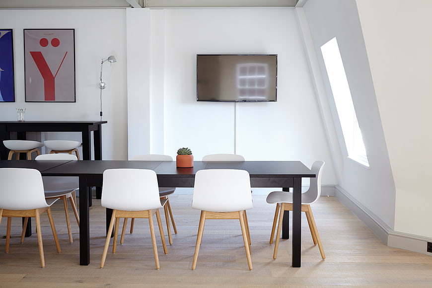 Modern minimalist office meeting room with black table and white chairs