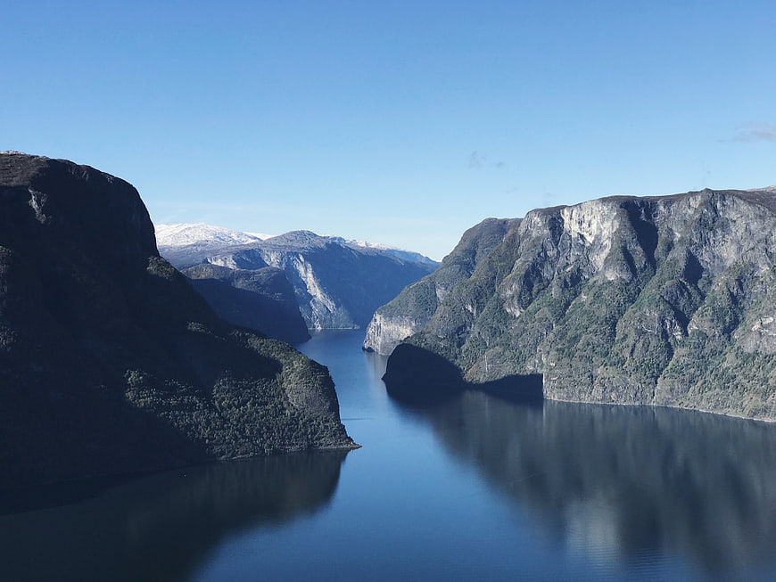 Aerial View of Dramatic Fjord with Steep Cliffs and Calm Blue Water
