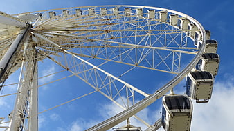 Low angle view of white Ferris wheel against blue sky