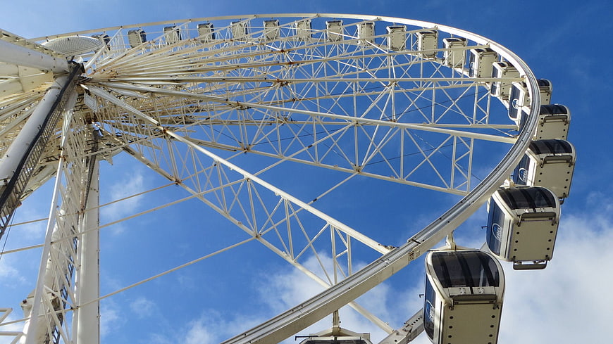 Low angle view of white Ferris wheel against blue sky