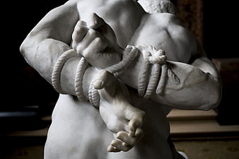 Close-up of marble sculpture with bound hands and rope
