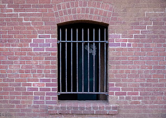 Weathered Brick Wall with Arched Barred Window