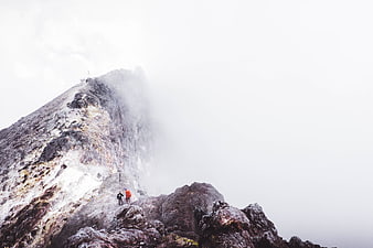 Hikers on Rocky Mountain Peak in Foggy Weather