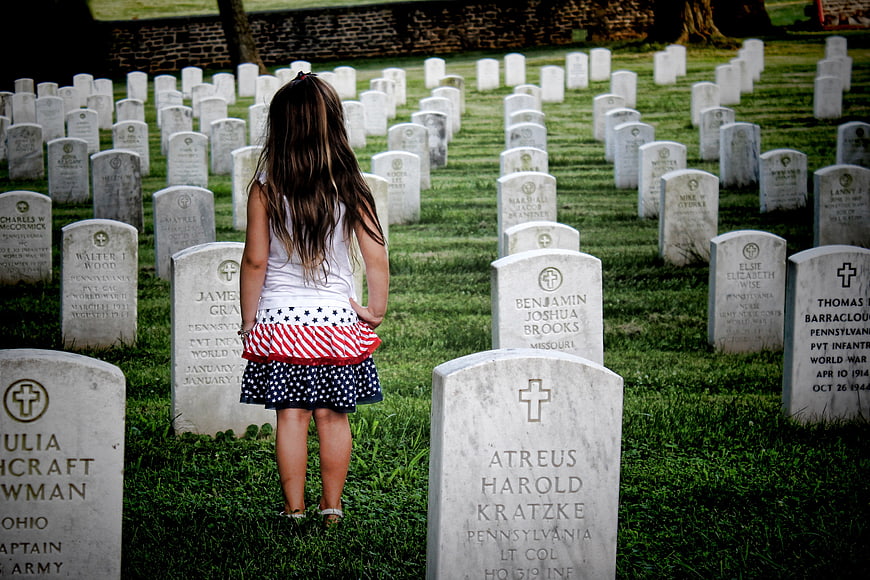 Little Girl in Patriotic Dress Walking Through Military Cemetery