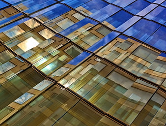 Abstract modern glass building facade with blue sky reflections