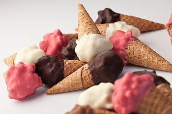 Assorted Chocolate Dipped Ice Cream Cones on White Background