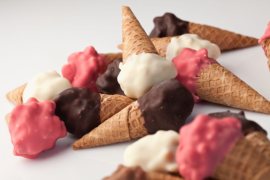 Assorted Chocolate Dipped Ice Cream Cones on White Background