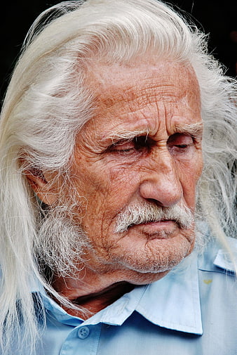 Close-up portrait of elderly man with long white hair