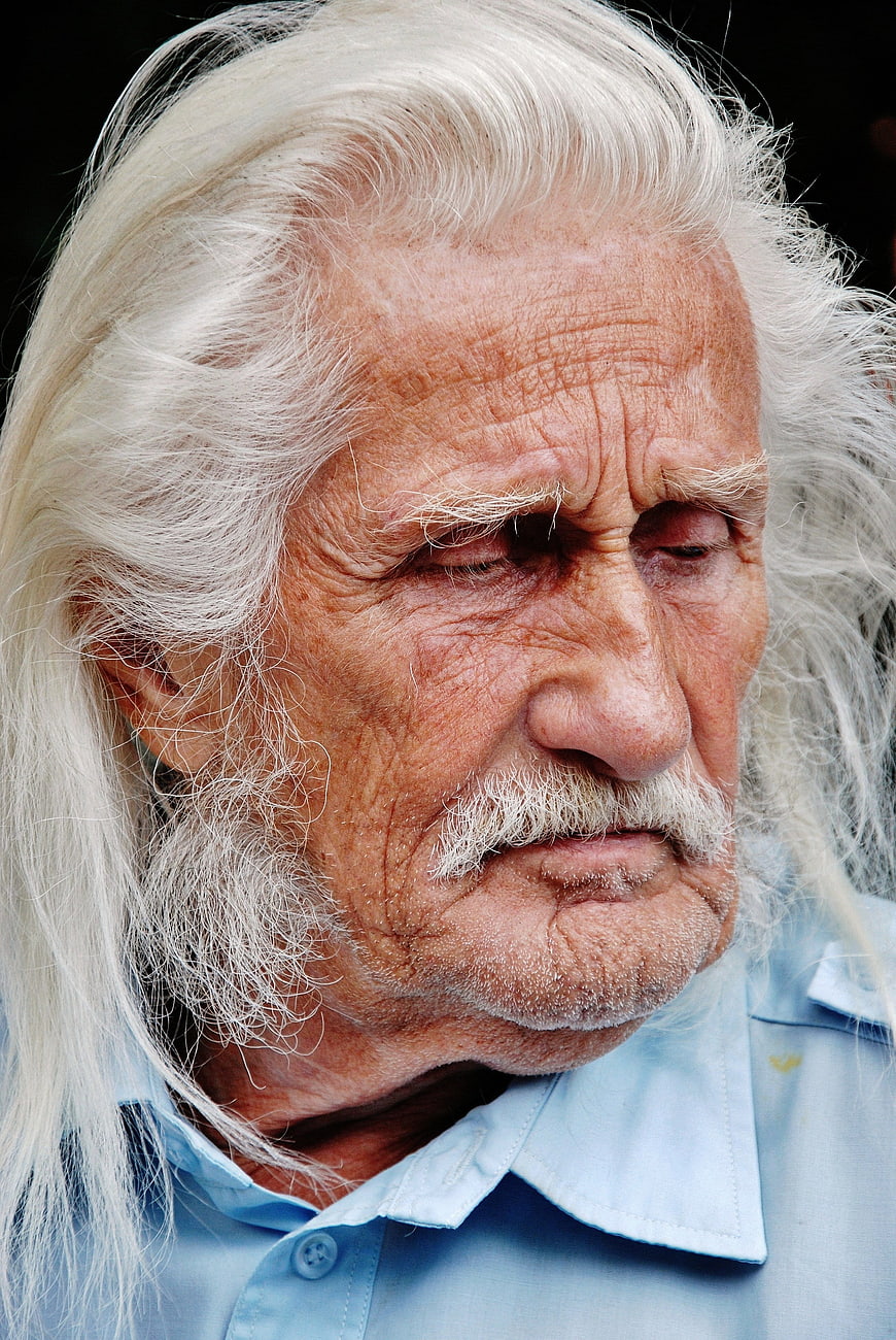 Close-up portrait of elderly man with long white hair