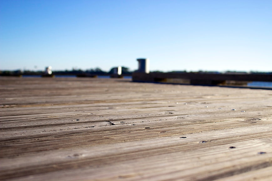 Close-up of wooden dock planks with blurred water background