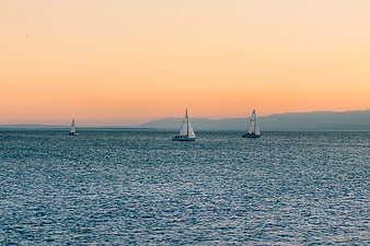 Three Sailboats on Calm Sea at Sunset