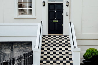 Classic black and white checkered stairs leading to a black door