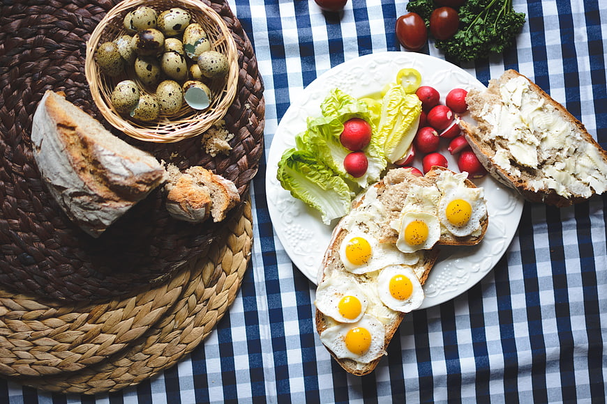 Top view of Easter breakfast with fried quail eggs on bread