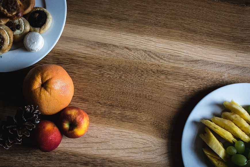 Top view of fresh fruit and pastries on wooden table