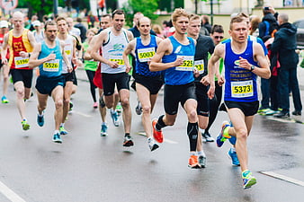 Male Marathon Runners Competing on Wet City Street