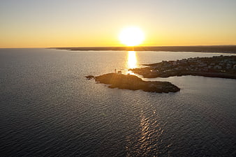 Aerial View of Coastal Lighthouse at Golden Sunset