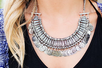 Close-up of woman wearing ornate silver coin necklace