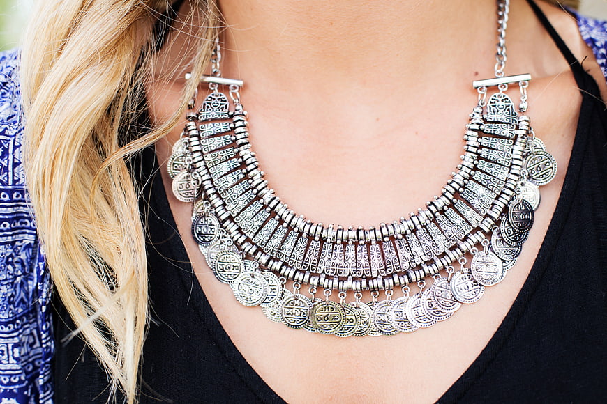 Close-up of woman wearing ornate silver coin necklace