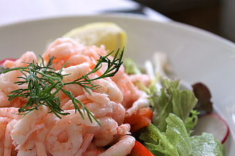 Close-up of fresh shrimp salad with dill and lemon