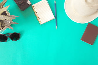 Flat lay of travel accessories on turquoise background