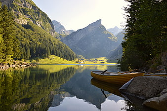 Serene Alpine Lake with Wooden Boat and Mountain Reflections