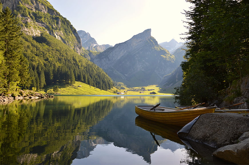 Serene Alpine Lake with Wooden Boat and Mountain Reflections
