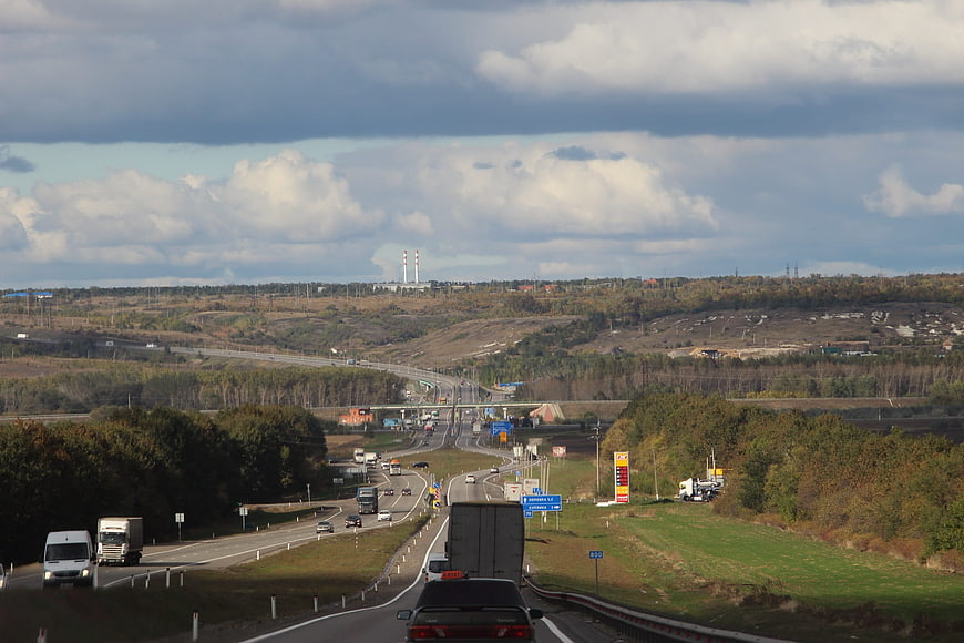 Highway traffic with trucks and cars in autumn landscape
