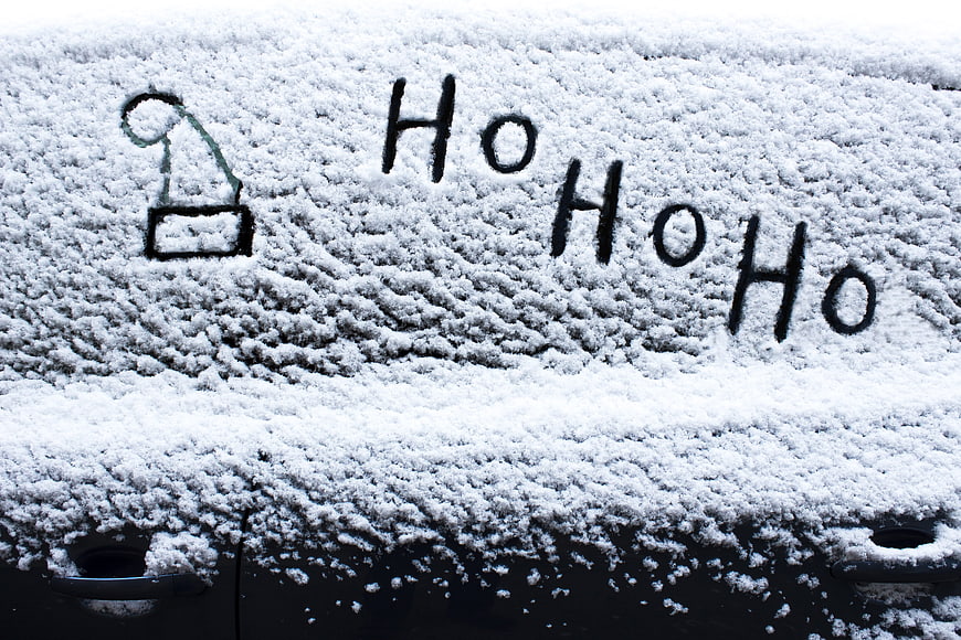 Ho Ho Ho Handwritten On Snowy Car Roof With Santa Hat Drawing
