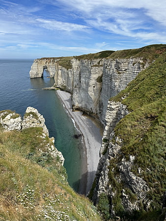 Dramatic white chalk cliffs and natural arch overlooking the sea