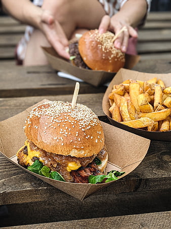 Delicious beef burger and fries on wooden table