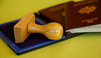 Wooden rubber stamp on ink pad with passports
