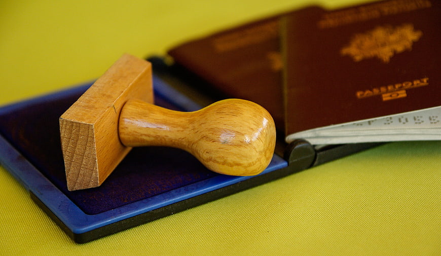 Wooden rubber stamp on ink pad with passports