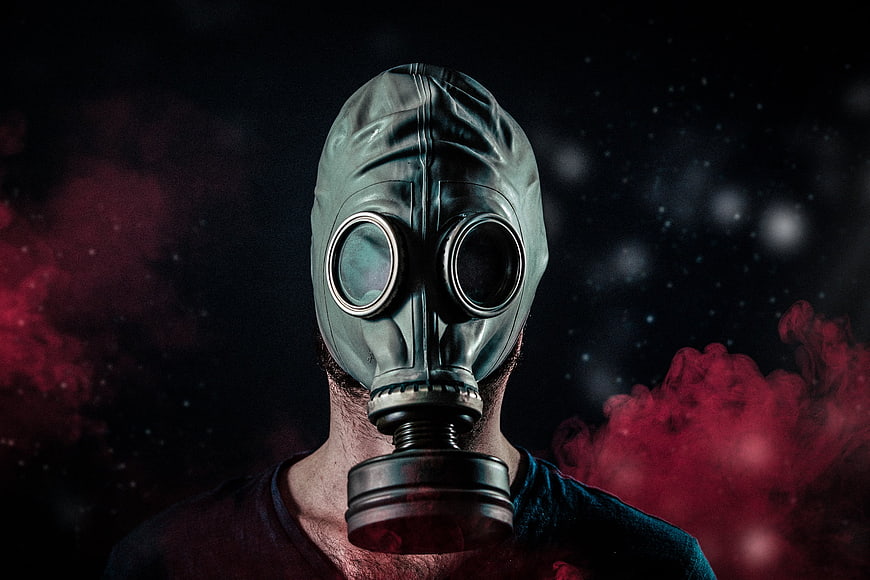 Man Wearing Gas Mask in Red Smoke