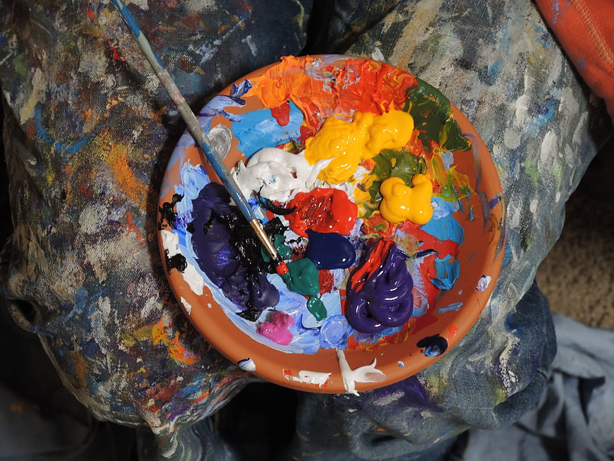 Close-up of artist palette with vibrant oil paints and brush